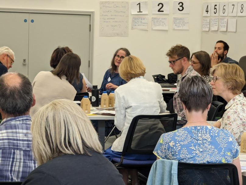 People sat around tables engaged in discussions