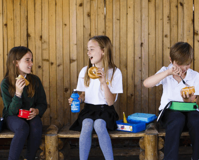 school children eating packed lunches