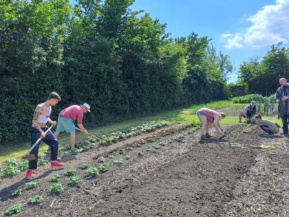 some students ploughing a field by hand
